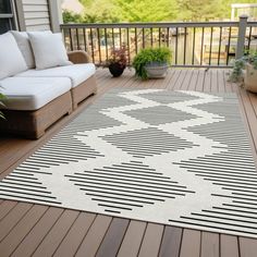 a white and black rug sitting on top of a wooden deck