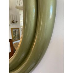 two green oval mirrors hanging on the wall