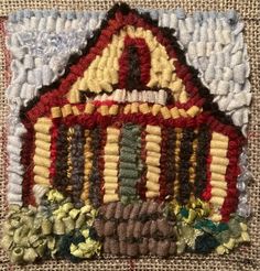 a close up of a small house made out of yarn