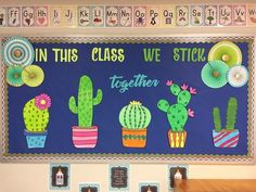 a bulletin board with cactuses and flowers on it in this class we stick together