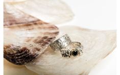 a silver ring sitting on top of a shell