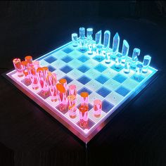 a lighted chess board with cups and glasses on it