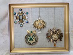 there are many brooches on display in this framed frame, and the bead work is gold