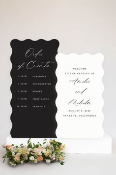 a wedding ceremony sign with flowers on it and a welcome card for the couple to come