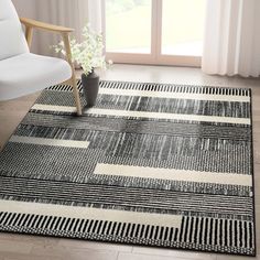 a black and white area rug in a living room with a chair next to it