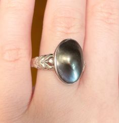 Lovely and substantial solitaire ring! Featuring a gorgeous 16x11mm oval black blister pearl with some iridescence, and two 0.01 diamond accents; set in 14k solid white gold. Marked 585 14k, and acid tested. This ring is a size 9.25 and weighs 4.17g Vintage condition: good/very good (minor wear on the back of the band; very minor wear on the setting). Pearls have a rich history steeped in legend and tradition, originating from the depths of the ocean where oysters create these luminescent gems. A foreign particle, like a grain of sand, triggers the oyster to coat it with layers of nacre, resulting in the creation of a pearl. The iridescence pearls exhibit are a result of the way light interacts with the layers of crystalline nacre. This intricate composition gives pearls their characterist Elegant Oval Solitaire Pearl Ring, Heirloom High Luster Oval Pearl Ring, Elegant Oval Pearl Ring With High Luster, Elegant Oval High Luster Pearl Ring, Elegant High Luster Oval Pearl Ring, Oval Tahitian Pearl Jewelry For Gift, Formal Solitaire Jewelry With Oval Cabochon, Elegant Silver Oval Pearl Ring, Classic Silver Ring With Tahitian Pearl