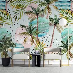 two chairs and a table in front of a wall with palm trees painted on it