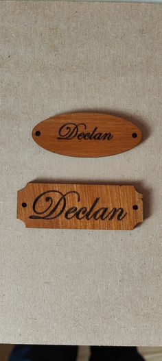 two wooden name tags sitting on top of a table