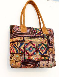 This bohemian banjara bag is the perfect accessory for the bohemian fashionistas. Key Features: Hand made in India. Fair trade guaranteed. Zipper top. Inside zipper pocket. Size ( Approx ) Height - 12 Inches/30 Cm. Width - 15 Inches/38 Cm. Handle Length 10 inches/ 25 Cm.  Inside Pocket - 3 ( As you can see in the picture ) Zipper Pocket - 1 Made from vintage Banjara  mirror work embroidery, it's a strong bag, and the perfect size for all your essential everyday stuff and more.... You'll get a look with a fashionable element of boho, and it will also team beautifully with your classic pieces. A bag for all seasons, and a bag that compliments a variety of looks is a very handy thing to have....it's a design I've been using myself for years, and can highly recommend! Material: 100% Cotton Ban Multicolor Embroidery Shoulder Bag For Festivals, Bollywood Embroidered Shoulder Bag For Festivals, Bollywood Style Embroidered Rectangular Shoulder Bag, Bollywood Style Embroidered Shoulder Bag For Festivals, Embroidered Multicolor Satchel Tote, Multicolor Shoulder Bag For Travel And Festival, Festival Shoulder Bag With Multicolor Embroidery And Handwork, Multicolor Shoulder Bag For Festival Travel, Multicolor Embroidered Handwork Shoulder Bag For Festivals