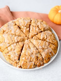 a white plate topped with cookies covered in icing next to an orange and pink napkin