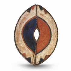 a circular object with an orange, blue and brown design on the inside of it