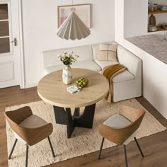 a living room with a white couch and wooden table in the center, surrounded by chairs