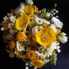 a bouquet of yellow and white flowers on a black background