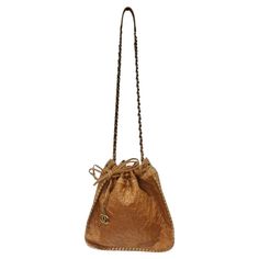 Stunning brown leather Chanel drawstring handbag circa 2011! Brown leather is embossed with iconic Chanel camellias which gives this bag such an elegant touch. Featuring brass hardware, a brass and interwoven leather crossbody style chain as the strap, and a brass chord stitching going along the perimeter as the finishing touch. A gorgeous cherry red lining is accompanied by a zip-fastening pocket as well as a slip pocket to ensure all of your belongings remain secure all day. The bag is complet Drawstring Handbag, Chanel Camellia, Hobo Crossbody Bag, Boho Aesthetic, Chanel Vintage, Cherry Red, Brass Hardware, Missoni, Head Scarf