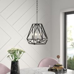 a dining room table with pink chairs and a chandelier hanging from the ceiling