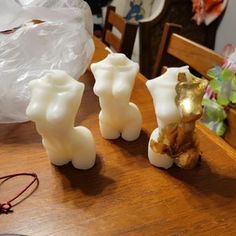 three white candles sitting on top of a wooden table