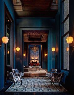 the hallway is decorated in blue and has two chairs on either side of the door