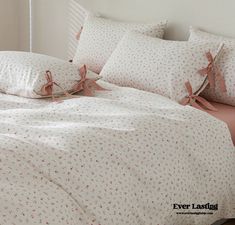 a bed with pink and white comforters on top of it