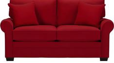 a red couch with two pillows on it