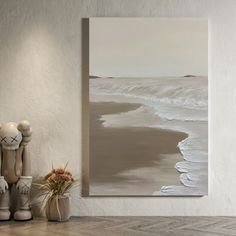 a painting is hanging on the wall next to a vase with flowers