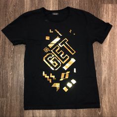 Available In “Like New” Condition Is A Zara Man Black/Gold “Get” T-Shirt Sz. Large. Comes From A Smoke Free Home-No Holes/Tears/Stains (See Pics-Indentation Noted). Bundle & Save - Add’l 15% Off When You Bundle 2+ Items. Note: I’m Pretty Meticulous About What I List, So Know I Will Disclose Any Flaws. However, I Apologize If There Are Ever Any Oversights. I Strive For 5-Star Service. Shirt Was Not Worn Only Tried On-Don’t Have Tags. Any ?’S Let’s Connect! Thanks For Shopping By & Follow Me! Zara Black Short Sleeve T-shirt, Gold T-shirt With Letter Print For Summer, Gold Graphic Tee With Crew Neck, Zara Graphic Tee For Streetwear, Gold T-shirt With Screen Print, Short Sleeve, Gold Graphic Tee With Short Sleeves, Gold Short Sleeve T-shirt With Screen Print, Trendy Black Zara T-shirt, Zara Text Print Top For Streetwear