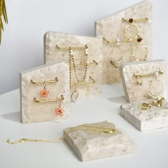 several different types of earring and necklaces are displayed on a white countertop