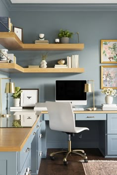 a home office with blue walls and shelvings on the wall, along with a white chair