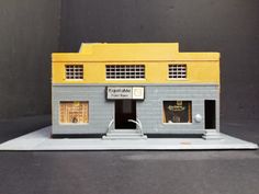 a toy model of a small building with two stories and three doors on the front