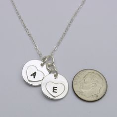 Keep your loved ones with you always, with this classic circle fingerprint with birthstone charm necklace. Handcrafted in solid sterling silver, this necklace features a beautiful circle fingerprint pendants hanging at different levels from your choice of chain. This trendy charm necklace design is both simple and elegant. The necklace is available with different charm sizes, different chains and different necklace lengths. With its durable construction and timeless design, this necklace is sure Minimalist Hand Stamped Heart Pendant Jewelry, Anniversary Hand Stamped Round Disc Charm Necklaces, Everyday Hand Stamped Heart Pendant Jewelry, Sterling Silver Round Pendant Necklace For Anniversary, Mother's Day Sterling Silver Charm Necklace With Round Pendant, Mother's Day Sterling Silver Round Disc Charm Necklace, Sterling Silver Charm Necklaces For Mother's Day, Silver Hand-stamped Heart Pendant Jewelry, Sterling Silver Round Disc Charm Necklace For Mother's Day