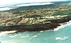 an aerial view of a small town by the ocean and land area with houses on it