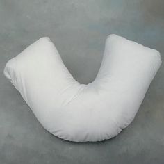 a white pillow sitting on top of a gray floor