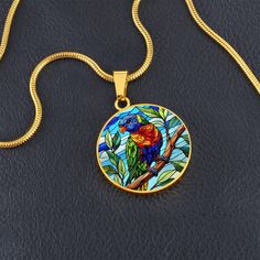 Capture the vibrant beauty of the Rainbow Lorikeet with this stunning pendant necklace. The intricate design showcases the bird's multicolored plumage in rich hues of blue, green, yellow, and red. Perfect for nature lovers and bird enthusiasts, this piece adds a splash of color and a touch of the wild to any outfit. Forged from premium surgical steel and available with a lavish 18k gold finish, this innovative jewelry boasts our exclusive design, handcrafted with care right here in the U.S.A by Round Pendant Necklace With Bird Design For Gift, Bird Design Necklace Gift, Necklace With Round Pendant And Bird Design For Gifts, Round Necklace With Bird Design For Gift, Bird Design Round Pendant Jewelry For Gifts, Bird Design Round Pendant Jewelry As Gift, Bird Design Round Pendant Jewelry Gift, Gift Jewelry With Bird Design Round Pendant, Round Pendant Jewelry With Bird Design For Gift