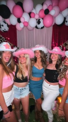 a group of young women standing next to each other in front of a balloon arch