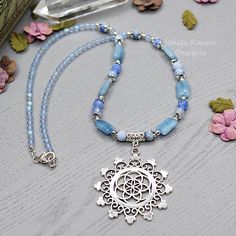 "A one of a kind, natural crystal witch aesthetic necklace featuring a beautiful flower of life, mandala pendant. This Blue Agate crystal beaded necklace was created with  blue agate, denim quartz and Vintage Czech glass beads with lead and nickel free silver accents. This boho necklace is finished with a silver plated lobster clasp and I can add an extender chain if you wish (just comment in the note to seller at checkout) At \"matinee length\" this flower of life necklace is designed to sit ju Luxury Blue Beaded Crystal Necklaces, Spiritual Flower Pendant Necklace With Gemstone, Bohemian Necklace With Flower Pendant As Gift, Bohemian Flower Pendant Necklace As Gift, Bohemian Gemstone Flower Pendant Jewelry, Bohemian Flower Pendant Gemstone Jewelry, Spiritual Crystal Necklace With Gemstone Beads And Round Pendant, Spiritual Round Pendant Crystal Necklace With Gemstone Beads, Spiritual Crystal Necklace With Round Gemstone Pendant