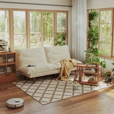 a living room filled with furniture and lots of windows next to a wooden coffee table