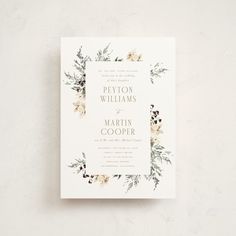 a wedding card with flowers and greenery on the front is shown in white paper