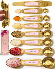 gold measuring spoons with pink labels on them next to other measuring spoons and spices