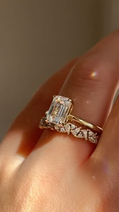 a close up of a person's hand with a diamond ring on their finger