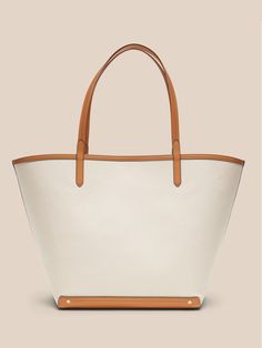 An elegant companion to everyday style, this classic tote goes anywhere with ease with spacious storage, sturdy leather trim, and a snap closure.  Sturdy leather handles.  Open top with snap closure.  Height: 16" (41cm) Width: 25" (63cm) Depth: 8" (2 Canvas Leather Tote, Leather Handles, Open Top, Canvas Leather, Everyday Style, Leather Trim, Leather Handle, Leather Trims, Leather Tote