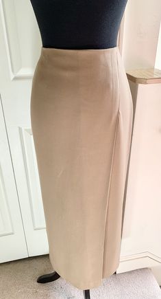 Simply styled with a clean line, this slim skirt has a single, 4" deep, offset front pleat, and a 16" deep back vent for ease in walking. 98% wool, 2% spandex, skirt has a gorgeous, fluid drape. Invisible back zip and hook close. Fully lined, size 4, color Camel. Never worn.  Actual color is closest to second and third photos.  Dimensions: Waist 27" circumference  Hip 37" circumference  35" garment length waist to hem Rock Hat, Slim Skirt, Skirts With Boots, Womens Skirts, Saks Fifth, Saks Fifth Avenue, Womens Skirt, Bathing Beauties, Size 4