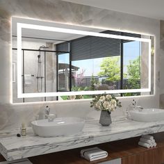 a bathroom with two sinks and a large mirror over it's counter top,