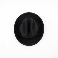 Our newest release is a hard wool style that also features a brand new crown shape. This Cattleman crown shape on our Field Fedora is a throwback to classic American headwear. A 2 3/4" flange up brim with brim binding. All leather is manufactured in a solar and wind powered facility that collects 27,300 tons of rainwater per year, and uses 50% natural light energy. Fit: Due to the stiff/firm nature of our hard wool, we recommend to check your head shape on our online fit guide below. The Field F Classic Black Adjustable Fedora, Artisan Black Wide Brim Fedora, Black Wool Fedora With Flat Brim, Black Artisan Brimmed Fedora, Artisan Black Flat Brim Fedora, Malibu Surf, Wetsuit Men, Surf Gear, Sustainable Leather