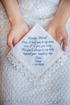 a person holding a white handkerchief with blue writing on it