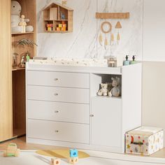 a baby's room with white furniture and toys