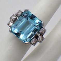 Art Deco 18K (.750) white gold ring, decorated with emerald-cut Aquamarine stone and accented with single-cut Diamonds - approx. 0.2 ctw., VS clarity, color G-H. This majestic ring is a size 6 1/2, 18 mm wide and weighs 12.9 grams. EA2895 Aquamarine Brilliant Cut Diamond Ring For Formal Occasions, Formal Aquamarine Diamond Ring With Brilliant Cut, Luxury Diamond Ring With Rectangular Stone, White Gold Gemstone With Emerald Brilliant Cut, Luxury Emerald Cut Gemstone With 17 Jewels, Luxury Emerald Cut Sapphire Ring With Diamond Detail, Exquisite Diamond Topaz Ring For Formal Occasions, Octagon White Gold Emerald Ring With Brilliant Cut, Formal Aquamarine Ring With Diamond Accents