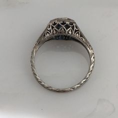 Details: Stunning Art Deco Period platinum and sapphire ring--would make a lovely wedding ring! The center stone is estimated .40 carats, and measures 4.9mm round. The filigree is beautiful on this ring, and is in lovely shape. This is a stunning ring--you will not be disappointed! Please ask all necessary questions prior to placing an order. Measurements: The size is 5 1/2 US and can be sized for a fee. Condition: The overall all condition of this ring is very good. Heirloom Sapphire Cluster Ring For Promise, Heirloom Sapphire Cluster Promise Ring, Classic Sapphire Halo Ring, Formal Sapphire Diamond Ring In Platinum, Classic Sapphire Birthstone Ring, Timeless Sapphire Promise Ring With Round Band, Formal Sapphire Diamond Cut Ring, Timeless Sapphire Promise Ring, Formal Sapphire-colored Diamond Ring