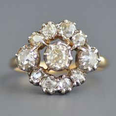 A fabulous antique Georgian period (1714-1837) old mine cut diamond ring in sterling silver & 14k yellow gold. This beautiful antique diamond ring features a sterling silver face with a gold back, as was typical of this period, with all antique romantic sparkling old mine cut diamonds cut down collet set in a wonderful circular pattern with the largest and warmest in the center flanked with medium sized diamonds on the sides and smaller diamonds on the top and bottom leading to a smooth simple g Antique Cluster Ring With Rose Cut Diamonds, Victorian Diamond Ring With Rose Cut In White Gold, Victorian White Gold Diamond Ring With Rose Cut Diamonds, Victorian White Gold Diamond Ring With Rose Cut, Antique Gold Diamond Ring With Rose Cut Diamonds, Antique Diamond White Ring With Diamond Accents, Victorian Diamond Ring With 17 Jewels, Victorian Style Diamond White Rose Cut Diamond Ring, Antique Hallmarked Diamond Ring