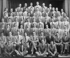 an old black and white photo of a group of men in suits posing for the camera