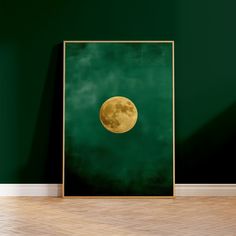 an empty room with a green wall and a gold framed art print on the wall