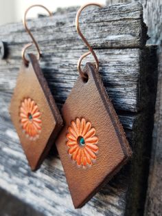 Beautifully dyed pair of floral earrings in warm colors of caramel, tobacco, and orange. Crafted by hand from start to finish, these earrings start out as blank slates of premium veg-tanned leather. From there, I hand-tool, dye, and paint each pair. As with most artisan jewelry, no two sets are alike. All leather pieces are conditioned with beeswax, which keeps leather supple and water resistant (see video). Edges and backs are conditioned and finished, as well. Please remember that time and wea Brown Flower Earrings With Ear Wire, Bohemian Orange Copper Earrings, Orange Copper Bohemian Earrings, Handmade Vintage Rust-colored Earrings, Handmade Vintage Rust Earrings, Handmade Rust Vintage Earrings, Artisan Orange Copper Earrings, Bohemian Brown Flower Jewelry, Handmade Orange Copper Earrings